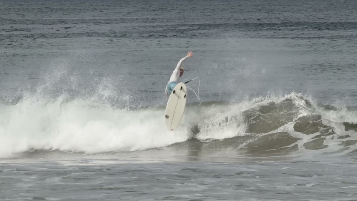 A surfer launches off the lip with the board in the air.